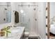 Modern bathroom with a glass shower, marble walls, and dark wood vanity at 513 Saint Charles Ne Ave, Atlanta, GA 30308