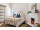 Cozy bedroom with a gold metal frame bed, fireplace, and a stylish rug on hardwood floors at 513 Saint Charles Ne Ave, Atlanta, GA 30308