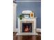 Close up view of a classic fireplace with white mantel, decorative tiles, and a warm fire at 513 Saint Charles Ne Ave, Atlanta, GA 30308