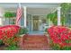 Inviting front porch with vibrant flowers, rocking chairs, and an American flag display at 513 Saint Charles Ne Ave, Atlanta, GA 30308