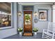 Inviting front porch with a wooden door, stylish sconces, and potted plants for added charm at 513 Saint Charles Ne Ave, Atlanta, GA 30308
