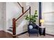 Elegant staircase with white spindles and wood railing, alongside a cozy chair, enhancing the home's charm at 513 Saint Charles Ne Ave, Atlanta, GA 30308
