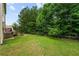 Large lawn in the backyard surrounded by a wooden fence, with deck and trees at 105 Arbor Creek Trl, Dallas, GA 30157