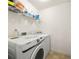 Well-lit laundry room with side by side washer and dryer, and storage shelving at 105 Arbor Creek Trl, Dallas, GA 30157