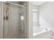 Well-maintained bathroom showcasing a shower, bathtub, and window providing natural light at 3698 Roseman Lndg, Cumming, GA 30040