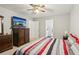 Cozy bedroom with striped bedding, ceiling fan, and furniture pieces for storage and organization at 3698 Roseman Lndg, Cumming, GA 30040