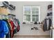Organized walk-in closet with shelves, hanging rods, and window for natural light at 3698 Roseman Lndg, Cumming, GA 30040