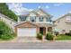 Charming two-story home with a brick facade, attached garage, inviting front porch, and manicured landscaping at 3698 Roseman Lndg, Cumming, GA 30040