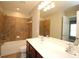 Well-lit bathroom with double sink vanity, tiled shower-tub combination, and neutral color palette at 942 Idlewood Dr, Canton, GA 30115