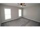 Bright bedroom featuring plush gray carpeting, a ceiling fan, and natural light from two windows at 942 Idlewood Dr, Canton, GA 30115