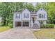 Two-story home with an open car port, white siding, and dark shutters, surrounded by lush greenery at 159 Aztec Se Way, Acworth, GA 30102