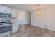 Modern kitchen with stainless steel appliances, white cabinets, hardwood floors, and adjacent dining area at 159 Aztec Se Way, Acworth, GA 30102