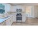 Modern kitchen featuring stainless steel appliances, white cabinets, hardwood floors, and subway tile backsplash at 159 Aztec Se Way, Acworth, GA 30102