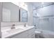 Bright bathroom featuring a double sink vanity, tiled shower, and glass doors at 3924 Ashford Dunwoody Road Northeast Ne Rd, Atlanta, GA 30319