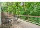 Inviting outdoor deck with metal furniture set surrounded by a lush, wooded landscape at 3924 Ashford Dunwoody Road Northeast Ne Rd, Atlanta, GA 30319