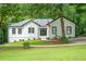 Charming white home with black trim and lush green lawn and mature trees at 3924 Ashford Dunwoody Road Northeast Ne Rd, Atlanta, GA 30319
