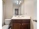 Well-lit bathroom featuring vanity with wood cabinets, white countertop, and traditional toilet at 3937 Covey Flush Sw Ct # 25, Smyrna, GA 30082