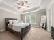 Spacious bedroom featuring a tray ceiling, a ceiling fan, and a large window at 3937 Covey Flush Sw Ct # 25, Smyrna, GA 30082