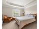 Calm bedroom with a cozy chair, tray ceiling, and large window at 3937 Covey Flush Sw Ct # 25, Smyrna, GA 30082