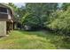 Backyard with mature trees, playhouse and stairs leading up to a deck at 10875 Shagbark Trl, Roswell, GA 30075