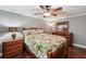 Comfortable bedroom with hardwood floors, ceiling fan, and matching wood furniture at 10875 Shagbark Trl, Roswell, GA 30075