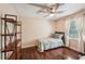 Bright bedroom with hardwood floors, ceiling fan, and shelving unit at 10875 Shagbark Trl, Roswell, GA 30075