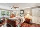 Spacious bedroom featuring hardwood floors, a ceiling fan, and stylish decor at 10875 Shagbark Trl, Roswell, GA 30075