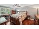 Cozy bedroom featuring hardwood floors, a ceiling fan, and natural light from the window at 10875 Shagbark Trl, Roswell, GA 30075