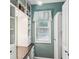 Well-lit closet features custom shelving, white cabinets, and a window with blinds at 10875 Shagbark Trl, Roswell, GA 30075