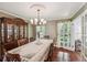 Formal dining room with hardwood floors, elegant lighting, and a large china cabinet perfect for entertaining at 10875 Shagbark Trl, Roswell, GA 30075