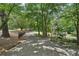 Long driveway leading to the house, framed by mature trees and a decorative black fence, adding privacy to the property at 10875 Shagbark Trl, Roswell, GA 30075