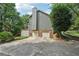 View of house with a two-car garage and wooden deck on upper level at 10875 Shagbark Trl, Roswell, GA 30075