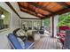 Inviting porch featuring wood floors, stone fireplace, overhead fan, and outdoor seating at 10875 Shagbark Trl, Roswell, GA 30075