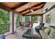 Beautiful porch with wood floors, stone fireplace, overhead fan, and comfortable furniture at 10875 Shagbark Trl, Roswell, GA 30075