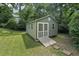 Backyard shed with double doors, wood ramp, and stone pavers at 10875 Shagbark Trl, Roswell, GA 30075