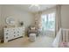 A beautiful Bedroom with neutral walls, plush carpet, and an adorable rocking chair at 1245 Mountain Ivey Ct, Sugar Hill, GA 30518