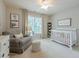 Cozy Bedroom featuring a chair, crib, and ceiling fan at 1245 Mountain Ivey Ct, Sugar Hill, GA 30518