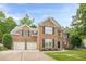 Charming two-story brick home featuring a two-car garage and manicured landscaping for a warm, inviting curb appeal at 1245 Mountain Ivey Ct, Sugar Hill, GA 30518