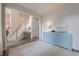 Bright foyer with blue accent cabinet, staircase, and neutral decor creates a welcoming entrance to the home at 1245 Mountain Ivey Ct, Sugar Hill, GA 30518