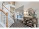 Bright foyer with hardwood floors, staircase, and decorative table with mirror creating a welcoming entrance at 1245 Mountain Ivey Ct, Sugar Hill, GA 30518