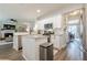 Open concept kitchen with white cabinets, granite counters, stainless steel appliances, and views into the living room at 1245 Mountain Ivey Ct, Sugar Hill, GA 30518
