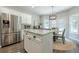 Bright eat-in kitchen features stainless steel appliances, white cabinets, and a breakfast nook with backyard views at 1245 Mountain Ivey Ct, Sugar Hill, GA 30518