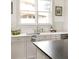 Bright kitchen features white shaker cabinets and granite countertops, as well as stainless steel appliances at 1602 Windsor Walk, Avondale Estates, GA 30002
