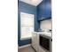 Well-lit laundry room with stylish wallpaper, upper cabinets, and modern washer and dryer at 1602 Windsor Walk, Avondale Estates, GA 30002