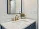 Modern bathroom vanity with marble countertop, brass faucet, and a stylish blue-framed mirror at 2760 Fraser Se St, Smyrna, GA 30080