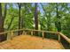 Wooden deck with black railings surrounded by lush greenery with an obscured background at 2760 Fraser Se St, Smyrna, GA 30080