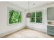 Bright dining area featuring hardwood floors, natural light, and modern light fixtures, with a view of lush landscaping at 2760 Fraser Se St, Smyrna, GA 30080