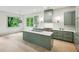 Modern kitchen with marble counters, stylish green cabinets, stainless steel appliances and beautiful natural light at 2760 Fraser Se St, Smyrna, GA 30080