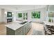 Bright, modern kitchen features an island, marble countertops, stainless steel appliances, and view to fireplace and backyard at 2760 Fraser Se St, Smyrna, GA 30080