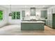 Modern kitchen featuring a marble countertop, large island, green cabinets, stainless steel appliances, and natural light at 2760 Fraser Se St, Smyrna, GA 30080